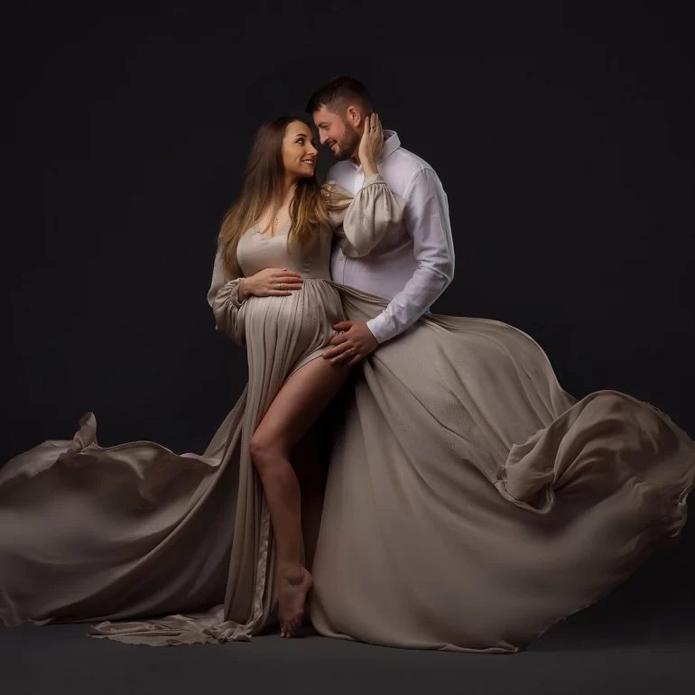 Maternity Photoshoot in North West London 23 Taupe fabric billows; romantic couple’s portrait against dark backdrop.