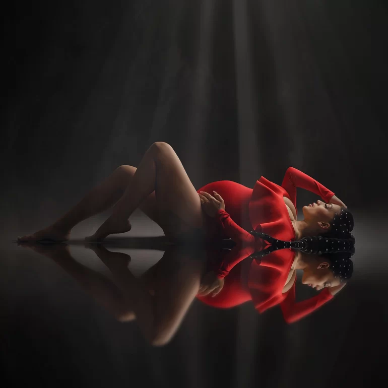 Maternity Photoshoot in North West London 29 Vibrant red gown, pearl‑adorned braids; beams of light, cinematic feel.