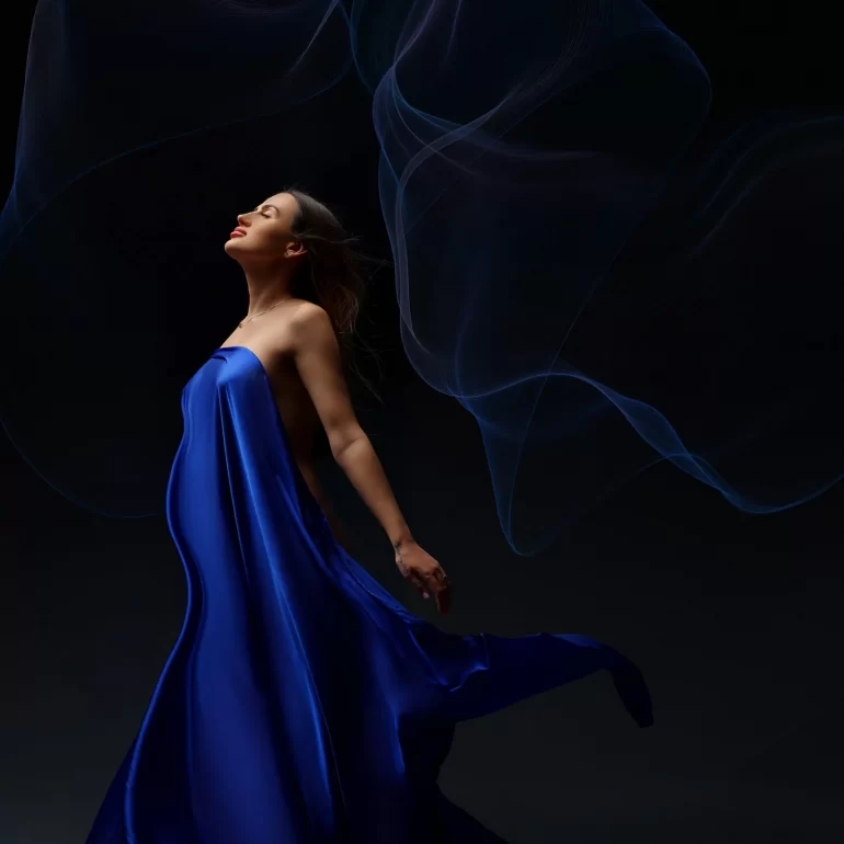 Maternity Photoshoot in North West London 30 Draped in blue satin; eyes closed as wisps of light swirl around.