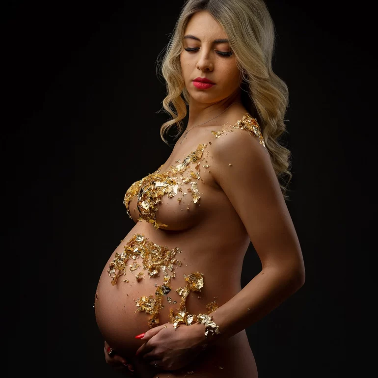 Maternity Photoshoot in North West London 34 Gold leaf art across shoulders, chest, and belly; dark, elegant backdrop.