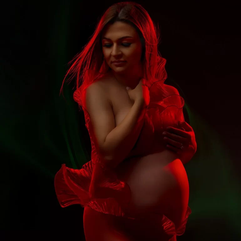 Maternity Photoshoot in North West London 44 Red and green lighting; flowing red fabric adds motion and drama.