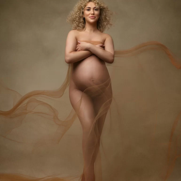 Maternity Photoshoot in North West London 49 Swirling sheer fabric, crossed arms; neutral palette, timeless elegance.