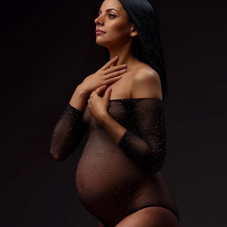 Maternity Photoshoot in North West London 12 Sheer sparkling black bodysuit; side‑lit expectant mother with calm expression.