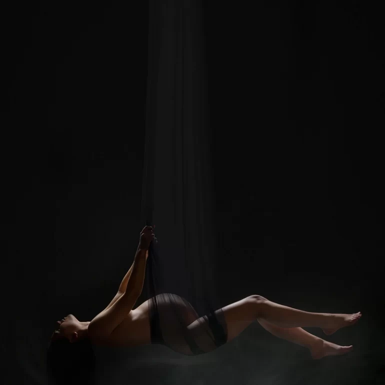 Maternity Photoshoot in North West London 13 Silhouette wrapped in sheer black fabric; soft light and mist, dreamlike.