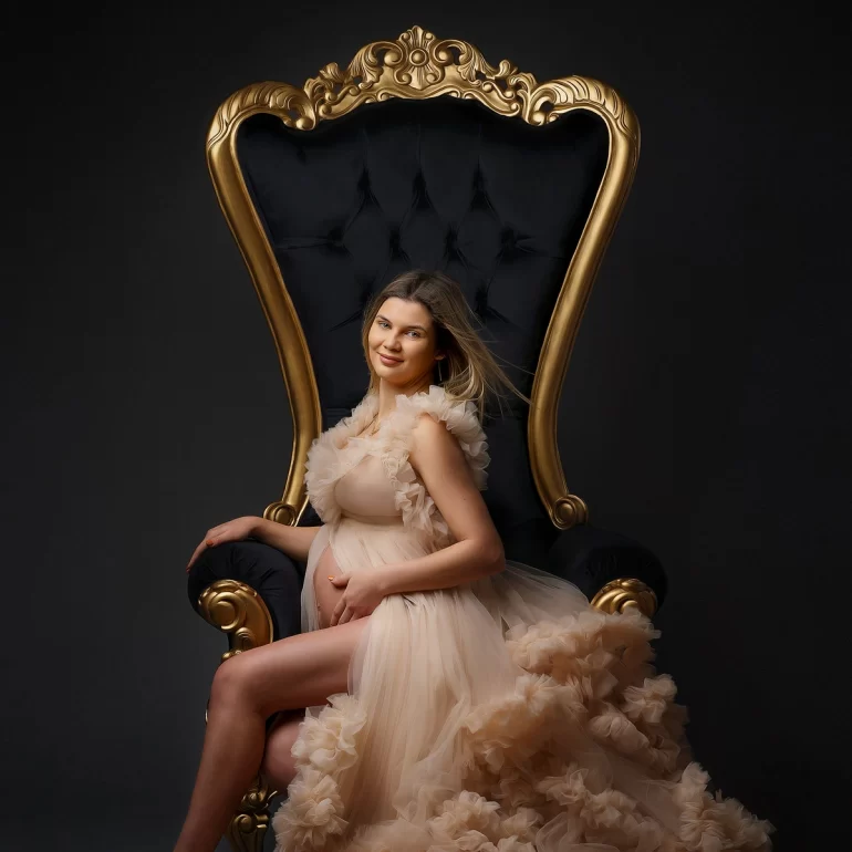 Maternity Photoshoot in North West London 65 Throne portrait; layered beige gown; gold and black luxury.