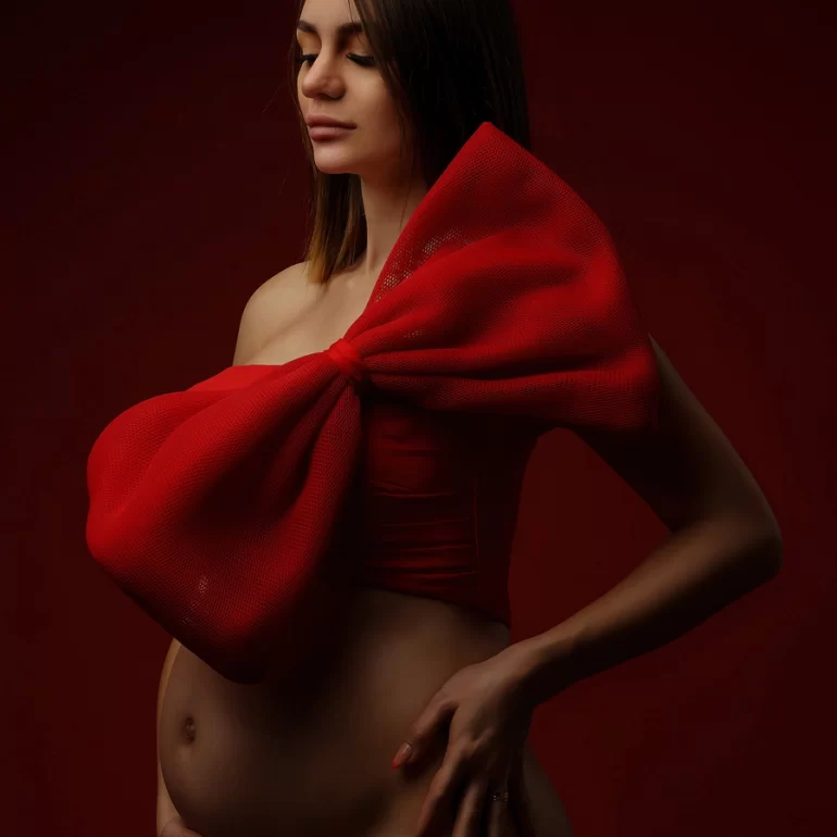 Maternity Photoshoot in North West London 68 Oversized red bow; deep red background; striking, artful statement.