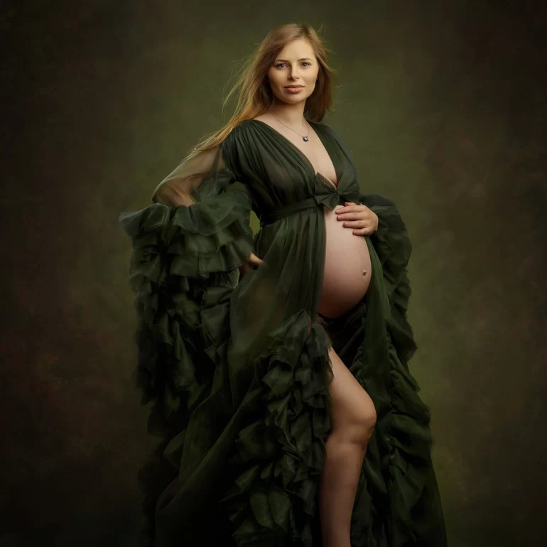 Maternity Photoshoot in North West London 15 Flowing dark‑green gown, barefoot; gentle hand on bump, serene studio.