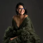 Photographer Mihaela Mocanasu wearing a green dress, smiling happily.