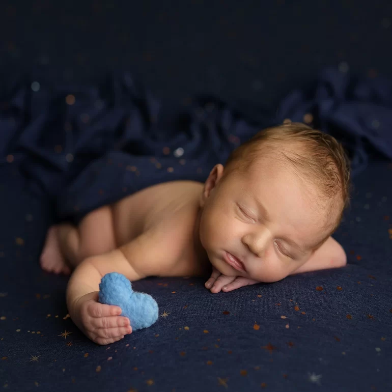 Newborn Photoshoot in North West London 15 Baby on dark blue with subtle stars, holding felt heart; tranquil feel.