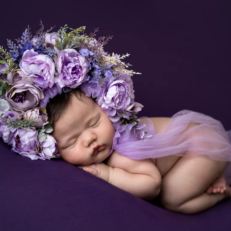 Newborn Photoshoot in North West London 31 Baby asleep on purple with lavender floral crown and soft drape.