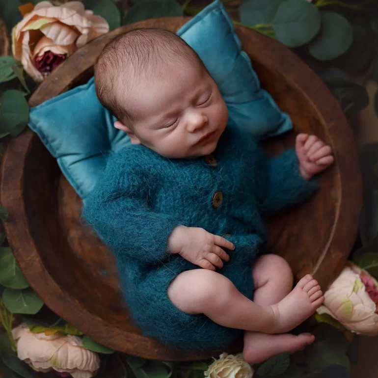 Newborn Photoshoot in North West London 42 Baby in teal knit nestled in rustic bowl with greenery and florals.
