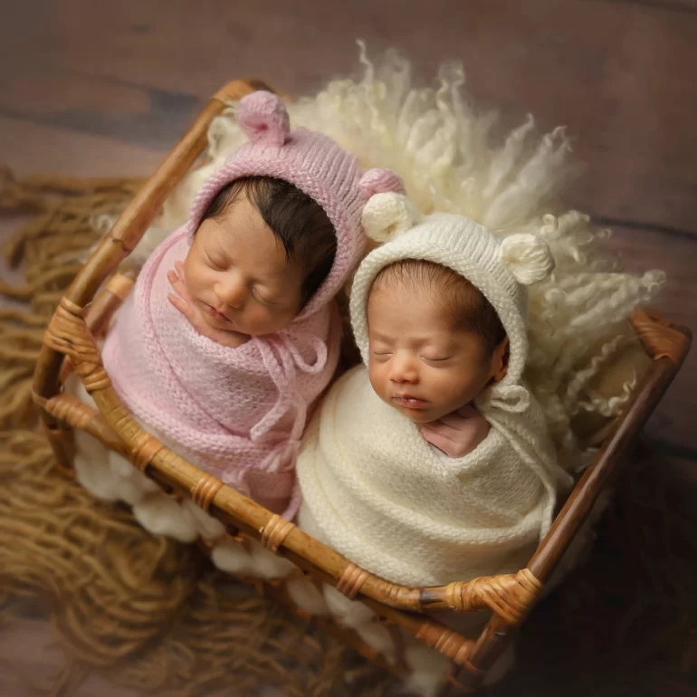 Newborn Photoshoot in North West London 60 Twin babies in pink and cream swaddles with bear‑ear bonnets in rustic basket.