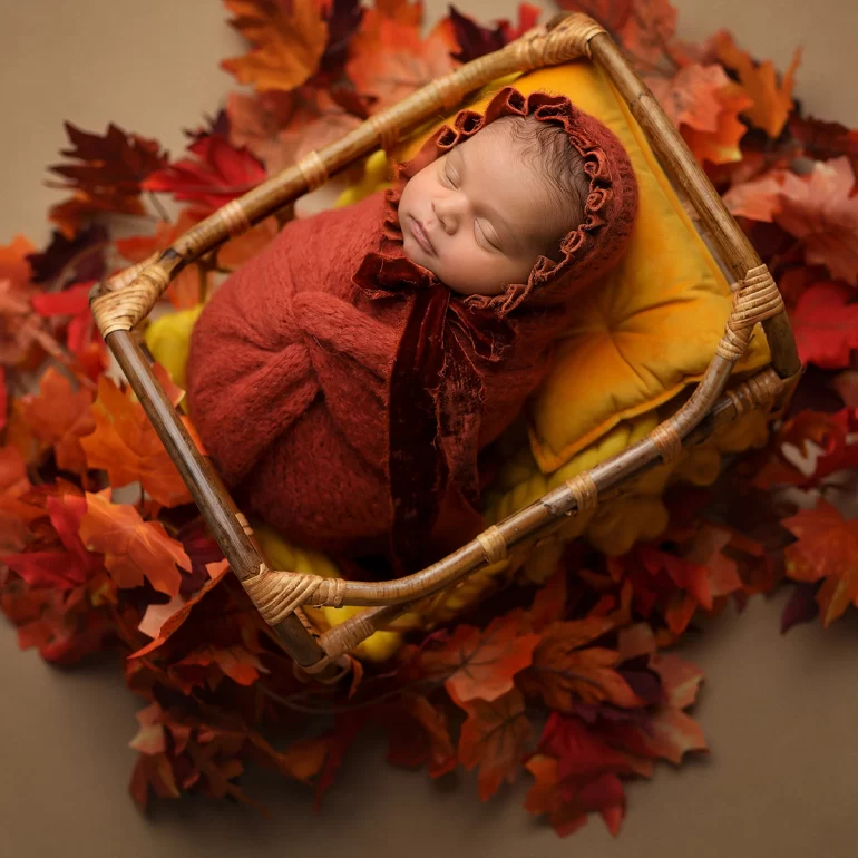 Newborn Photoshoot in North West London 73 Baby in rich red knit with lace bear‑ear bonnet holding tiny toy; purple set.