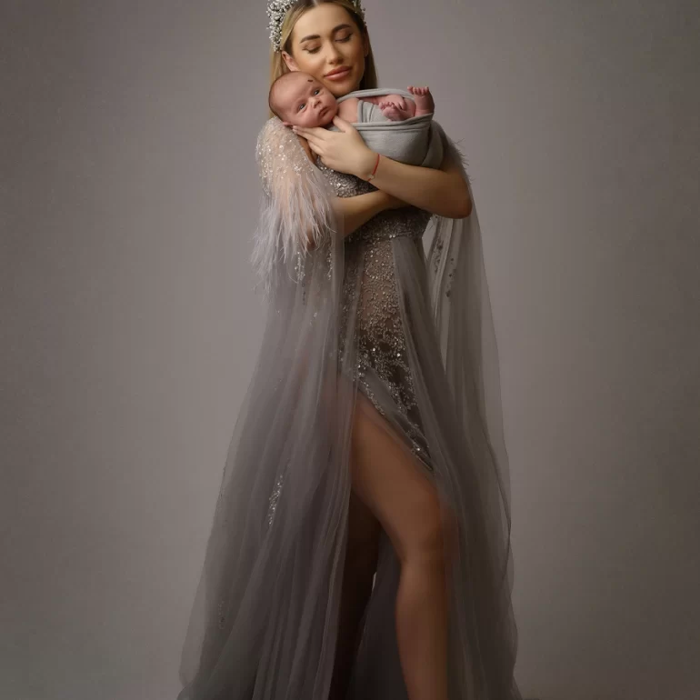 Newborn Photoshoot in North West London 75 Mother in silver sequin gown and tiara holding twins in soft grey wraps.