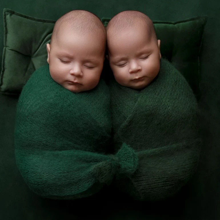 Newborn Photoshoot in North West London 77 Twin babies side by side in emerald wraps on matching green backdrop.