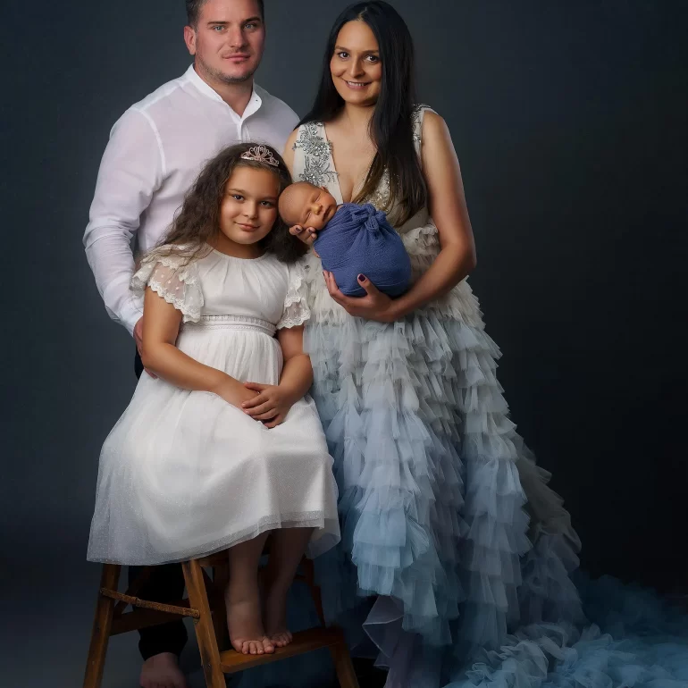Newborn Photoshoot in North West London 83 Family in blue and white tones with mother holding baby; daughter on wooden stool.