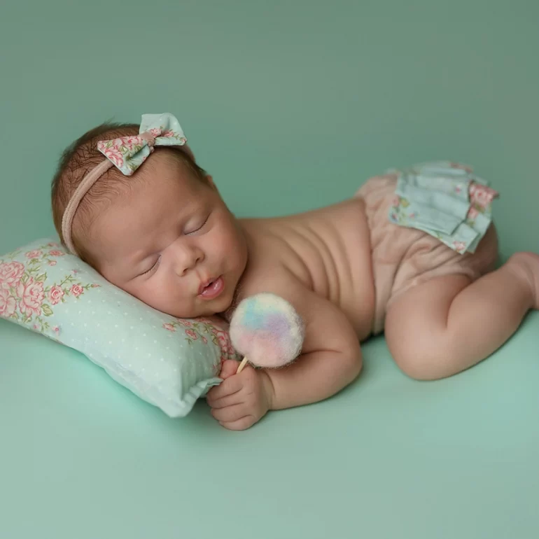 Newborn Photoshoot in North West London 87 Baby sleeping in relaxed pose on soft backdrop; clean, minimal portrait.