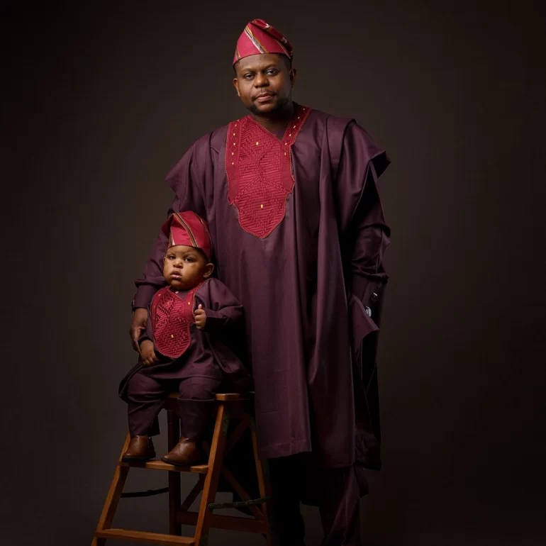 Family & Portrait Photoshoot in North West London 38 Father standing and son seated on stool in traditional maroon outfits with red embroidery.