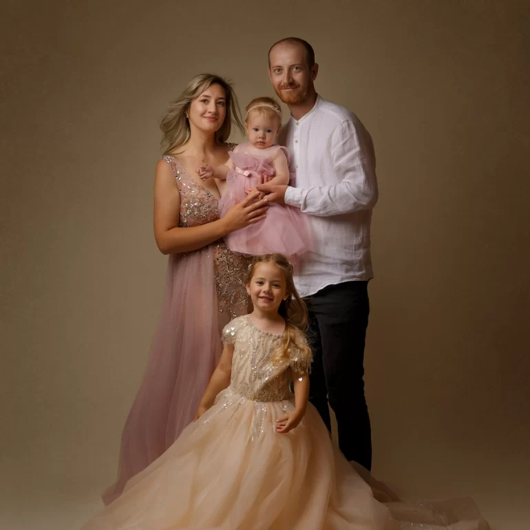 Family & Portrait Photoshoot in North West London 10 Parents with two daughters in pink and beige dresses; mother in sparkling gown.