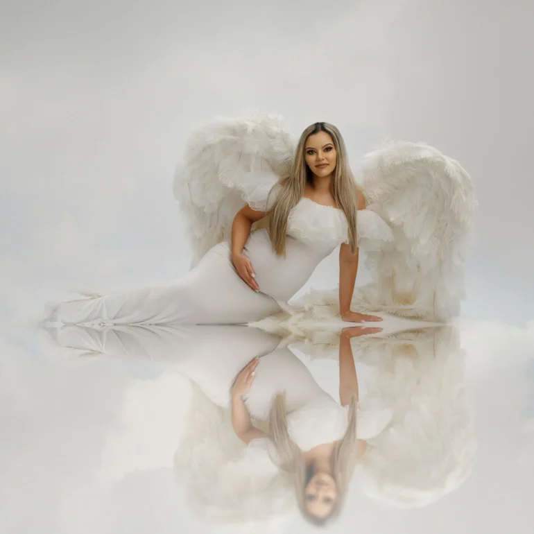 Maternity Photoshoot in North West London 85 White wings reflected on glossy floor; dreamy, cloud‑like background.