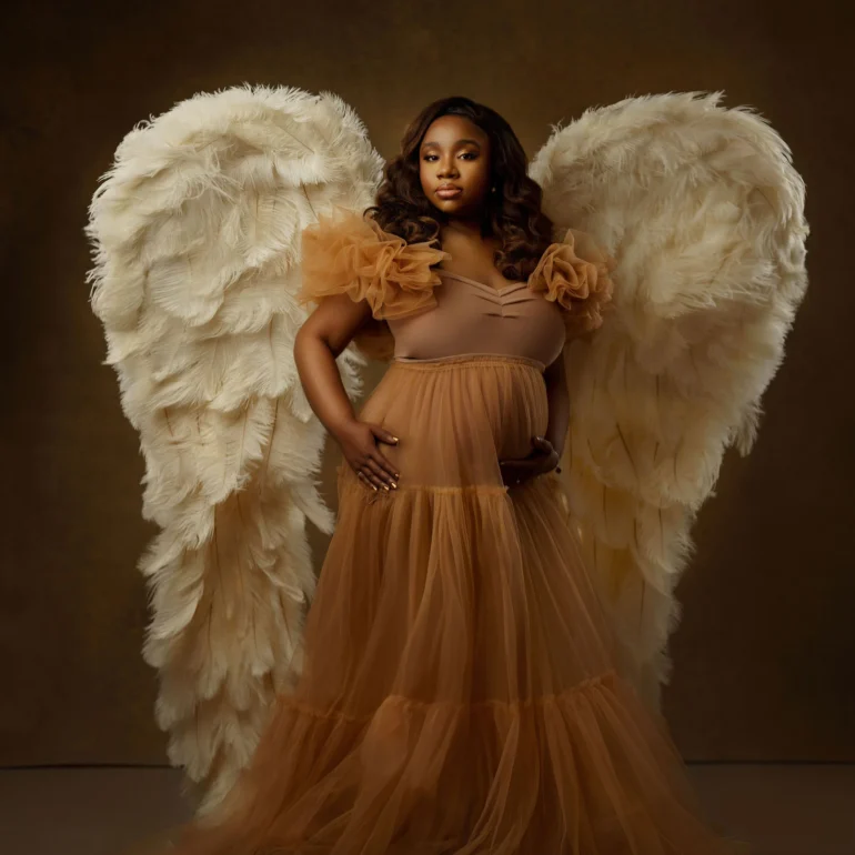 Maternity Photoshoot in North West London 91 Amber‑toned layered gown and large wings; heavenly studio presence.
