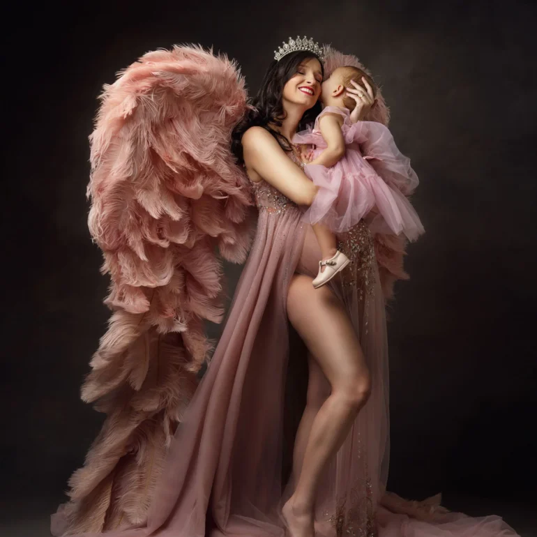 Maternity Photoshoot in North West London 93 Mother with child in coordinated pink; soft feathered wings; tender moment.