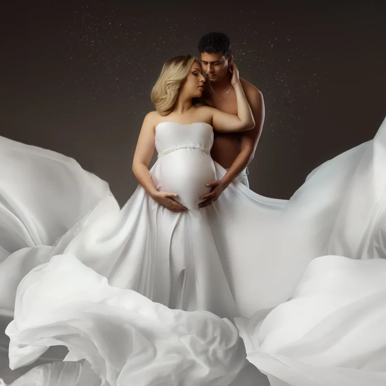 Maternity Photoshoot in North West London 73 Couple amid flowing white fabric; cloud‑like, magical effect.