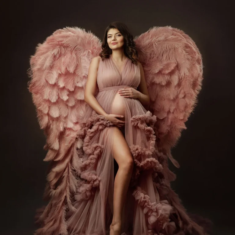 Maternity Photoshoot in North West London 6 Mother‑to‑be in blush ruffled gown with pink angel wings; dreamy studio.