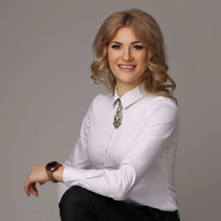 Family & Portrait Photoshoot in North West London 53 Smiling woman with blonde curls in white shirt and decorative tie; neutral backdrop.
