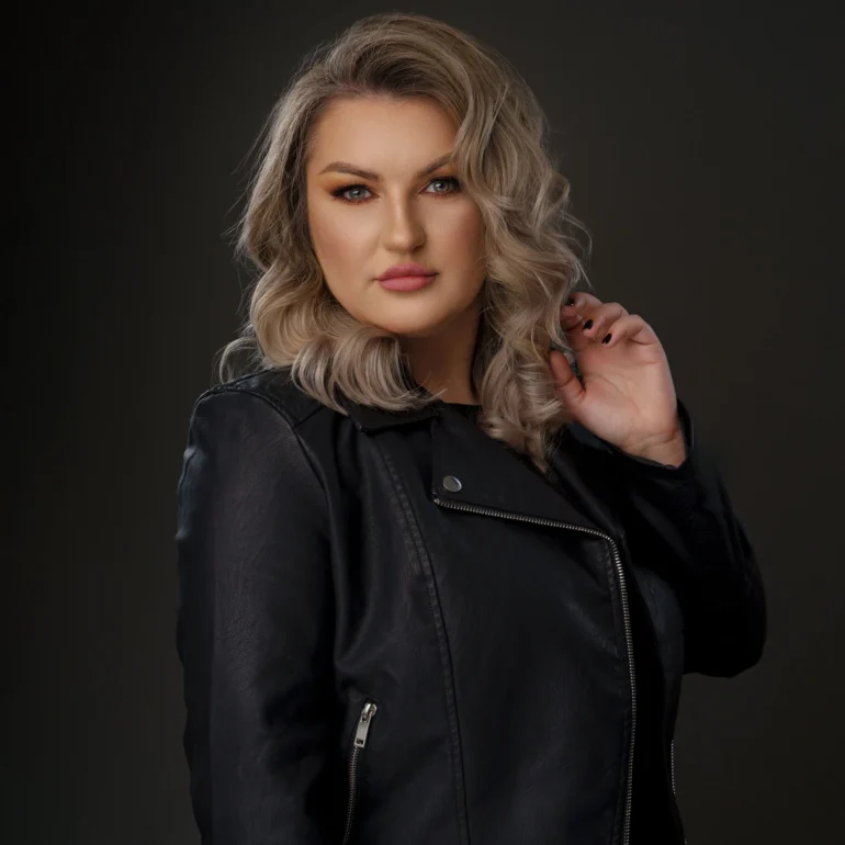 Family & Portrait Photoshoot in North West London 54 Woman with wavy blonde hair in black leather jacket posing against a dark studio set.