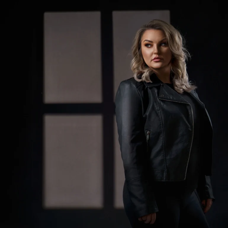 Family & Portrait Photoshoot in North West London 61 Woman in black leather jacket with window silhouette behind; dramatic studio lighting.