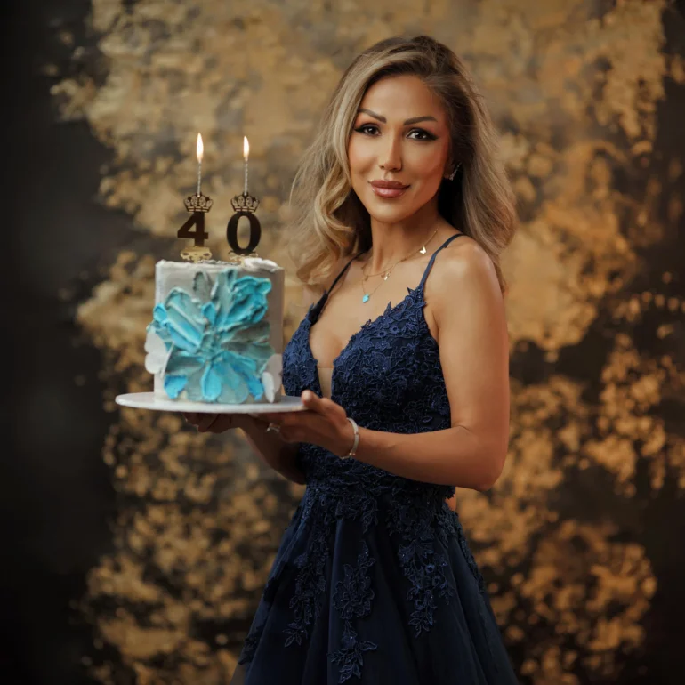 Family & Portrait Photoshoot in North West London 41 Woman in navy lace gown holding cake with 40 candles; gold‑accented studio set.